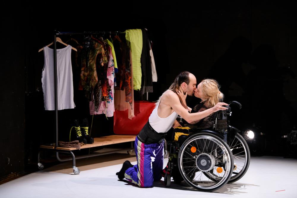 een persoon kust een persoon in een rolstoel