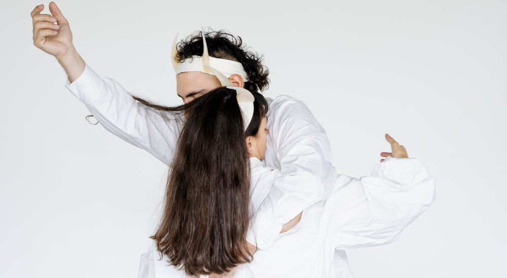 Two people in white shirts embracing each other with one arm