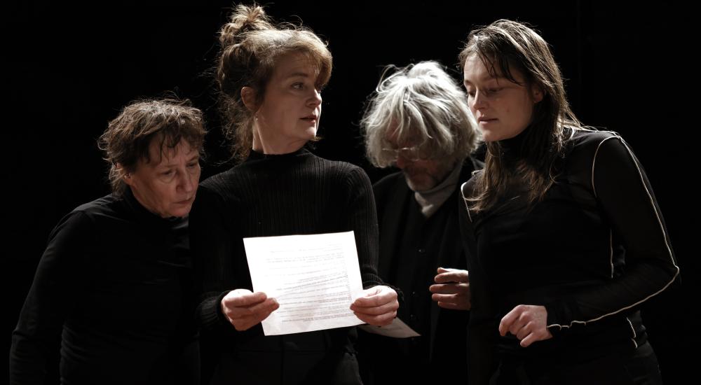 Three women and an man looking at a text 