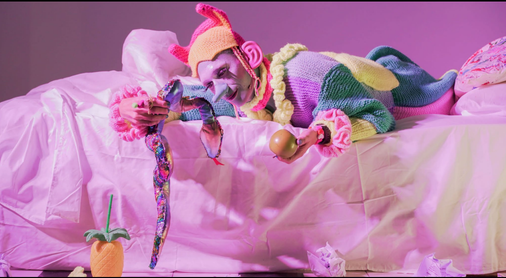 A drag creature (Taka Taka) lying on a pink bed