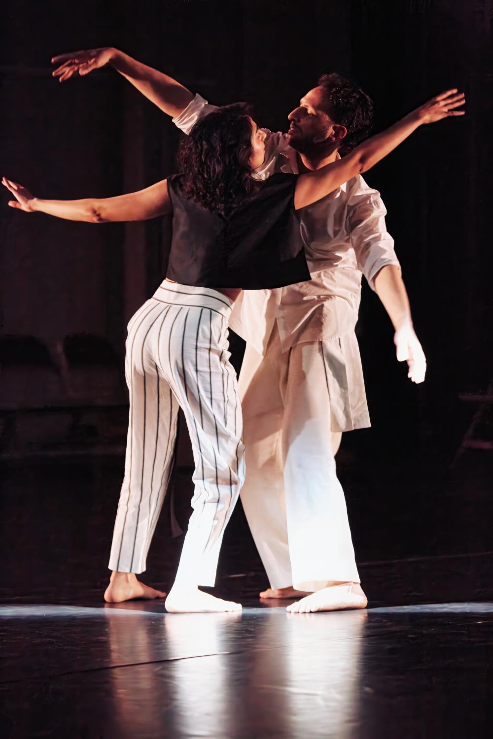two dancers with their arms in the air