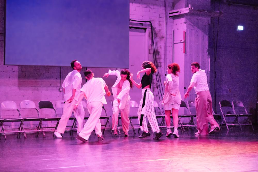 a group of dancers moving in pink light