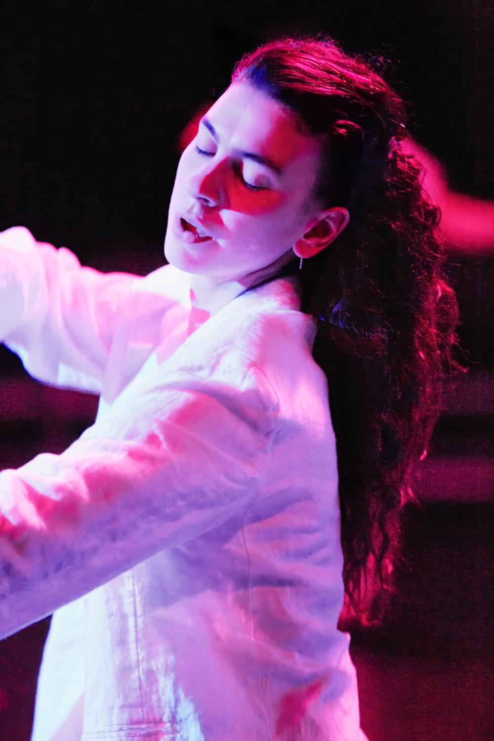 Dancer moving in pink light