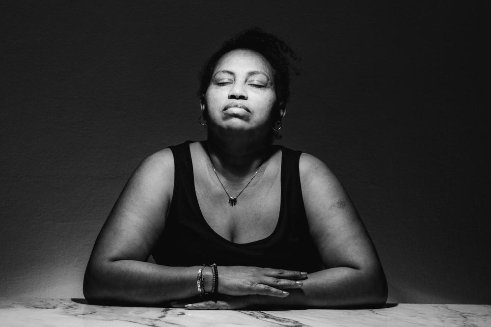 A woman sitting with her arms folded on a table