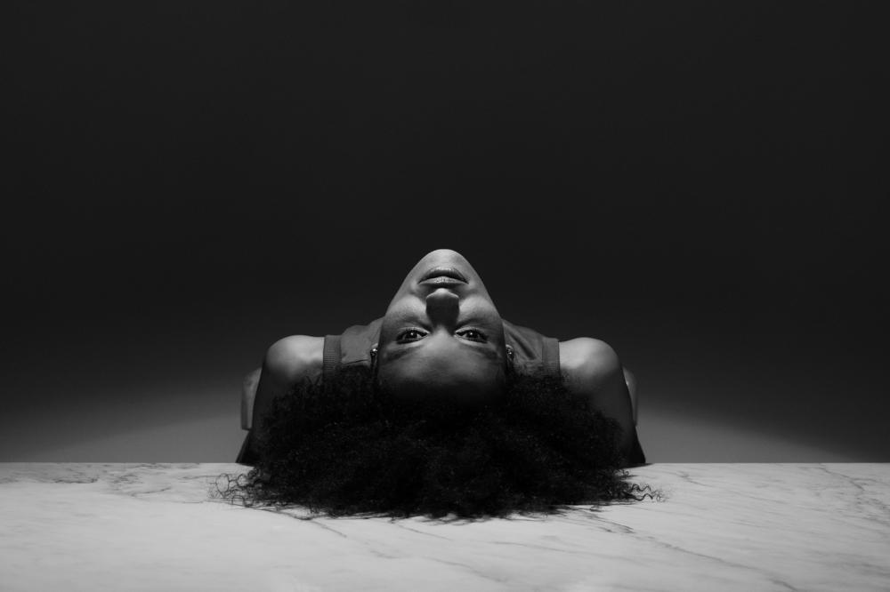 A woman lying with her back on a table looking at the camera