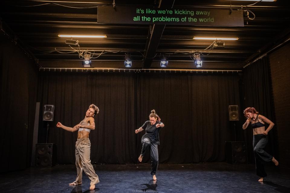 Three dancers mid-movement