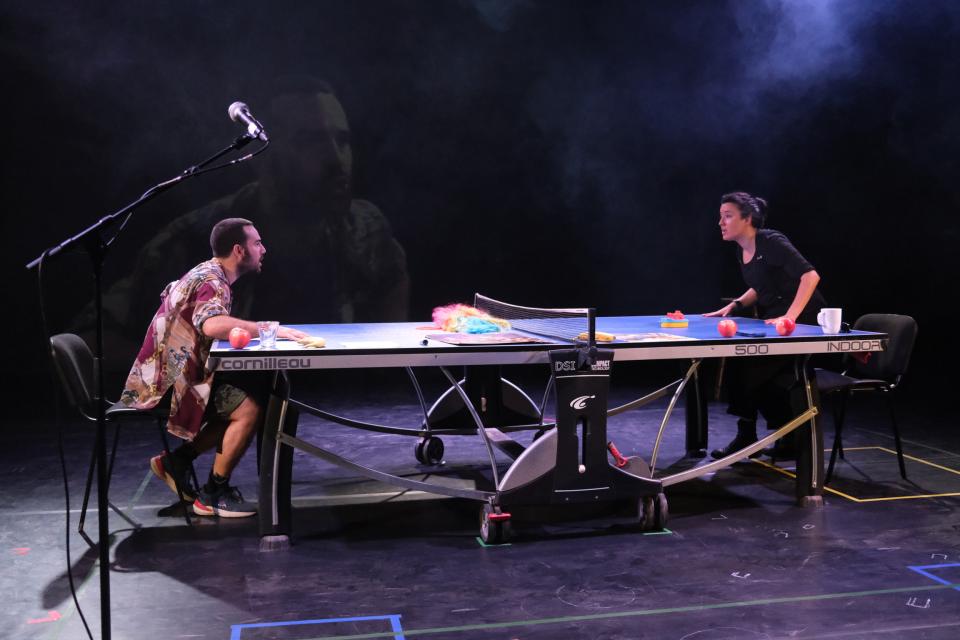 Two people leaning on a ping pong table 