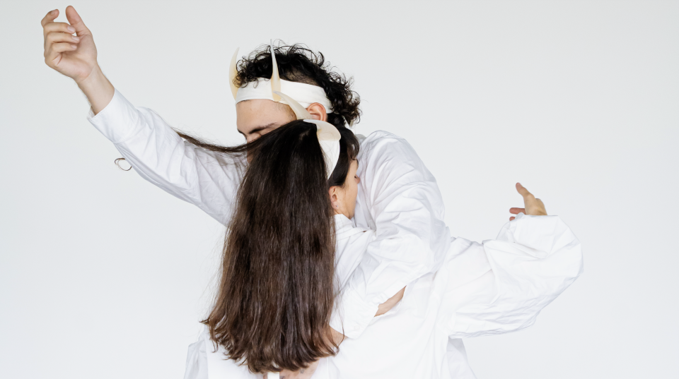 Two people in white shirts embracing each other with one arm