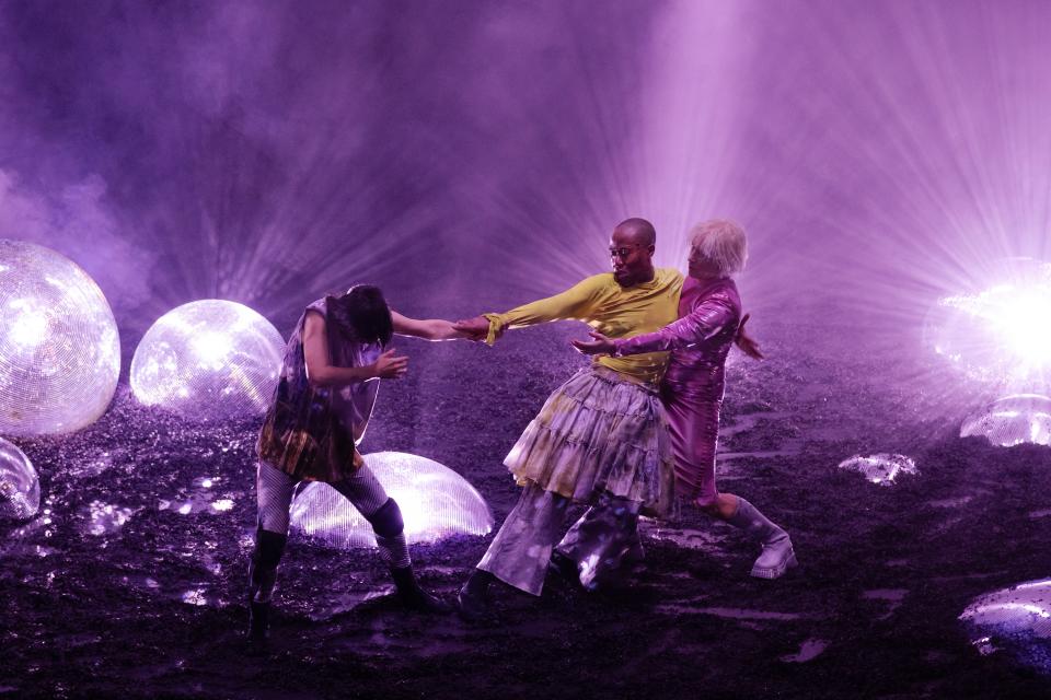 The three of them in front of purple lighting