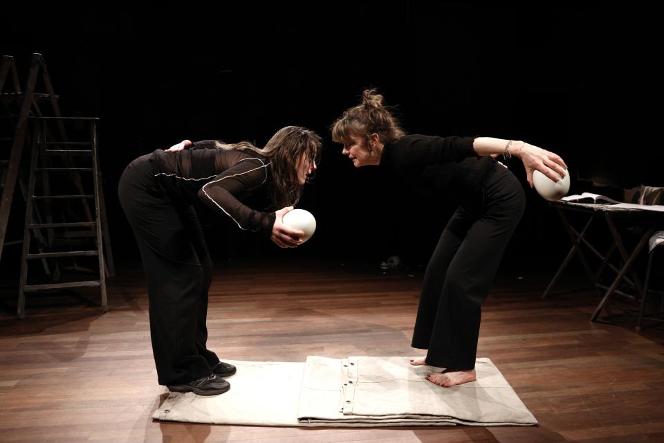 Two women bowing towards each other 