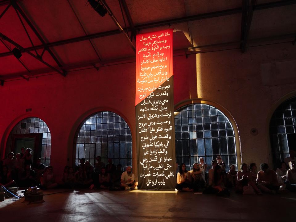 projection of an Arabic text on a wall in a large hallway