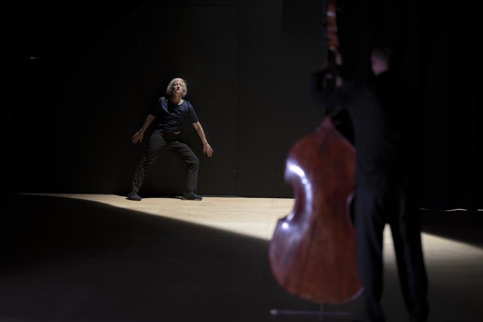 double bass player with performer on the background