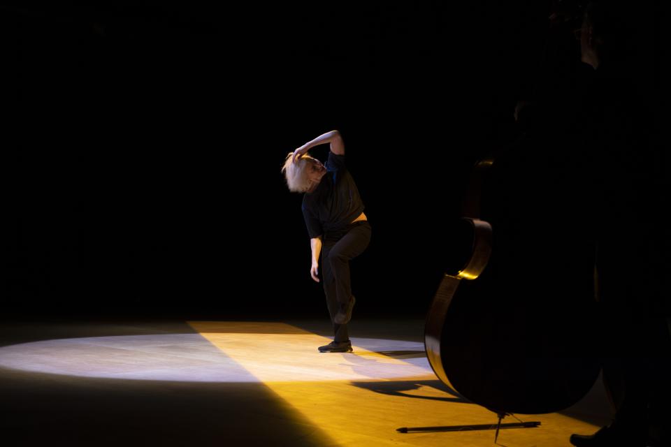 double bass player with performer on the background