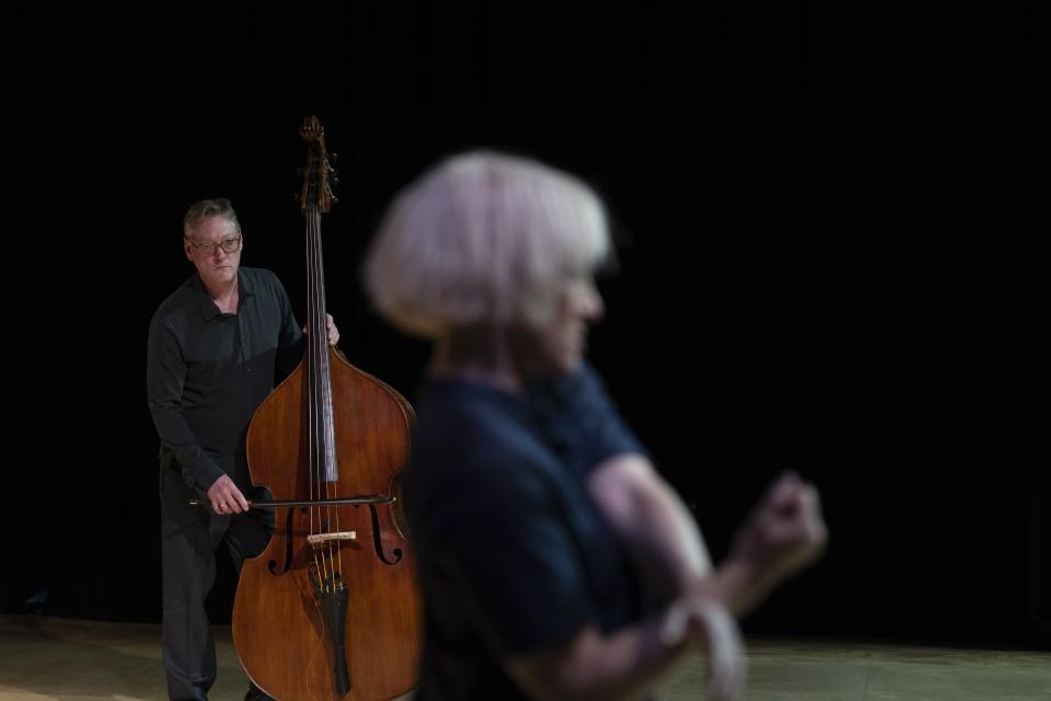 performer with double bass player on the background