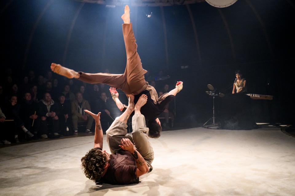 two acrobats and musician on stage