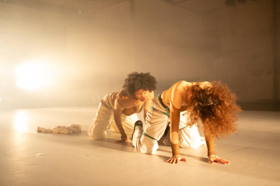 twee performers kruipen op het podium