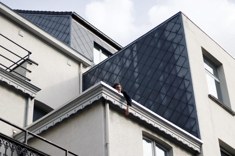 Jong persoon hangt over dak